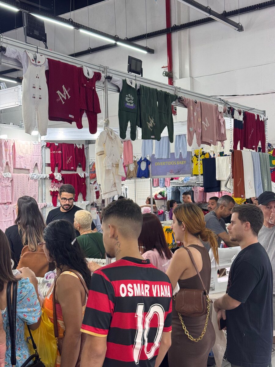 Corredor da feira lotado de famílias entre os stands