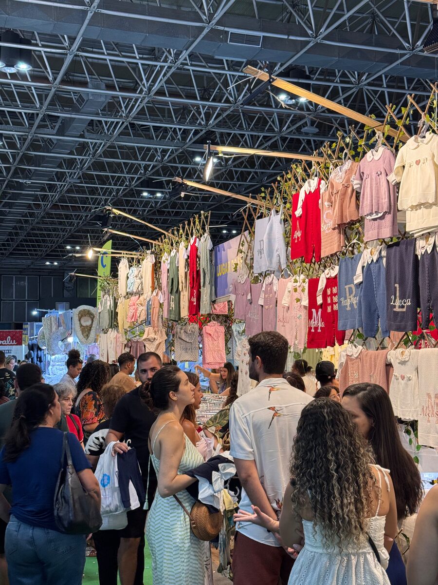 Araras de roupinhas de bebê em um stand da feira